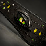 「Night Dragon」首輪のマクロ撮影：重ねた黒革のまぶたの下に輝く縦長瞳孔の緑のドラゴンアイ、クロコダイル型押しレザー、黄色のダイヤモンドインレイ、グリーンクリスタルとシルバースタッズ